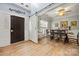 Elegant dining area with wood floors, barn door, a chandelier, and a table set for six, seamlessly connecting to the foyer at 2420 Ivy Creek Frd, York, SC 29745