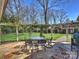 Charming backyard patio includes a dining set, grill, and beautifully landscaped yard with mature trees at 2423 Lemon Tree Ln, Charlotte, NC 28211