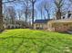 Expansive backyard with lush green lawn, covered patio, mature trees, and charming outdoor living spaces at 2423 Lemon Tree Ln, Charlotte, NC 28211