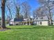 Beautiful backyard featuring a large manicured lawn, covered patio, and mature trees offering ample privacy at 2423 Lemon Tree Ln, Charlotte, NC 28211
