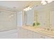 Bathroom featuring dual sinks, white tile, and a glass-enclosed shower at 2423 Lemon Tree Ln, Charlotte, NC 28211