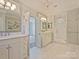 Luxurious bathroom with double vanities, a glass-enclosed shower, and neutral tiling at 2423 Lemon Tree Ln, Charlotte, NC 28211