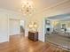 Elegant foyer boasts hardwood floors, a modern chandelier, and views into the living spaces at 2423 Lemon Tree Ln, Charlotte, NC 28211
