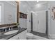 Modern bathroom featuring a glass enclosed shower, granite vanity, and decorative mirror at 2615 Farm House Ln, Monroe, NC 28110