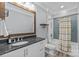 Bathroom featuring a tub with a shower, single sink, vanity, and a light blue accent wall at 2615 Farm House Ln, Monroe, NC 28110