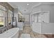 Elegant bathroom with a soaking tub, stone accent wall, and a walk-in shower at 2615 Farm House Ln, Monroe, NC 28110