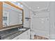 Bathroom showcasing double granite vanity, mirror, and shower with glass doors at 2615 Farm House Ln, Monroe, NC 28110