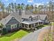 Stunning exterior elevation showcasing a craftsman-style home with a large front porch, beautiful landscaping, and a circular driveway at 2615 Farm House Ln, Monroe, NC 28110