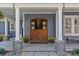 Inviting front entrance with custom wood doors, stone accents, and manicured landscaping at 2615 Farm House Ln, Monroe, NC 28110