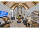 Bright living room with vaulted ceilings, wood beams, large windows, a stone fireplace, and hardwood floors at 2615 Farm House Ln, Monroe, NC 28110