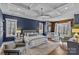 Luxurious primary bedroom with coffered ceilings, seating area, and natural light at 2615 Farm House Ln, Monroe, NC 28110