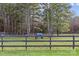 Horse with blue blanket standing in fenced-in pasture with trees in background at 2615 Farm House Ln, Monroe, NC 28110