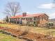 Charming brick home features a red metal roof and inviting covered porch at 262 Tuckers Grove Rd, Statesville, NC 28625