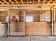 Horse peeking over the stall door, complete with metal bars and visible wood grain at 262 Tuckers Grove Rd, Statesville, NC 28625