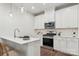 Bright kitchen features stainless appliances, white cabinets, pendant lights, and a breakfast bar with seating at 3051 Finchborough Ct # 219, Charlotte, NC 28269