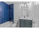 Stylish bathroom features blue tiled shower, sleek vanity, and modern fixtures at 315 Arlington Ave # 1206, Charlotte, NC 28203