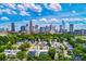 An aerial view of a city skyline, tree-lined streets and modern homes on a sunny day with blue skies at 318 Balboa St, Matthews, NC 28104