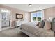 Bright bedroom with a large window, neutral colors, and an adjacent bathroom at 318 Balboa St, Matthews, NC 28104