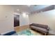 Neutral living room featuring a gray sofa, modern area rug, and a dark-stained front door at 333 W Trade St # 2503, Charlotte, NC 28202