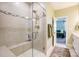 Bathroom featuring a glass enclosed shower with white tile and decorative border at 3925 Rothwood Ln, Harrisburg, NC 28075