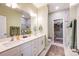 Bright bathroom features double sinks, white cabinets, walk in shower, and neutral decor at 3925 Rothwood Ln, Harrisburg, NC 28075
