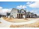 Street view of modern townhomes with manicured lawns on a sunny day with blue skies and white clouds at 3925 Rothwood Ln, Harrisburg, NC 28075