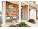 Inviting front porch featuring comfortable seating, beautiful stone accents, and a well-manicured garden at 3925 Rothwood Ln, Harrisburg, NC 28075