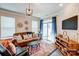 Cozy living room features a leather sofa, stylish decor, and sliding glass doors to the patio at 3925 Rothwood Ln, Harrisburg, NC 28075