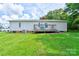 View of home's back exterior featuring a wood deck with railing and a lush green lawn at 4009 Polkville Rd, Shelby, NC 28150