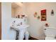 Cozy half bathroom featuring a pedestal sink, toilet, and decorative wall art at 4009 Polkville Rd, Shelby, NC 28150