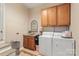 Functional laundry room features tile floors, utility sink, washer, and dryer at 534 Kirby Ln, Matthews, NC 28104