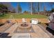 Cozy backyard patio with a charming fire pit, comfortable seating, and a serene view of the lush green yard at 534 Kirby Ln, Matthews, NC 28104