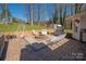 Brick paver patio with outdoor seating and a fire pit, surrounded by lush greenery and mature trees at 534 Kirby Ln, Matthews, NC 28104
