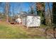 View of the yard storage shed sitting among the trees, along with a riding lawn mower at 534 Kirby Ln, Matthews, NC 28104