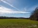 Expansive green field under a bright blue sky offers endless possibilities for development or recreation at 5534 Little Mountain Rd, Catawba, NC 28609