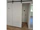 White laundry room with barn door and hardwood floors at 5825 Greene St, Charlotte, NC 28269