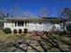 Charming home with a brick foundation, small front porch and mature bushes at 5924 Freedom Dr, Charlotte, NC 28214