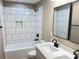 Modern bathroom with white subway tile, dark fixtures, a sleek vanity, and a well-lit mirror, blending style and functionality at 6756 Denver Heights Cir, Denver, NC 28037