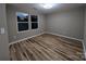 Bedroom featuring new hardwood floors, neutral paint, and natural light from two windows at 6756 Denver Heights Cir, Denver, NC 28037