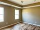 Spacious bedroom with hardwood floors and large windows, offering ample natural light and a view of the outdoors at 6756 Denver Heights Cir, Denver, NC 28037