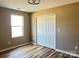 Bedroom with double bi-fold door closet, featuring hardwood floors, a neutral color scheme, and natural light from a nearby window at 6756 Denver Heights Cir, Denver, NC 28037