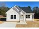 Charming single-story home with white siding, black roof, and a cozy front porch with views of the home's manicured front yard at 6756 Denver Heights Cir, Denver, NC 28037