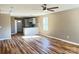 Bright open-concept living space with hardwood floors, seamlessly flowing into a modern kitchen with marble countertops and pendant lighting at 6756 Denver Heights Cir, Denver, NC 28037
