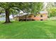 Sprawling backyard with brick home, wooden deck, and mature trees creating a serene and private outdoor space at 7770 Sherrills Ford Rd, Sherrills Ford, NC 28673