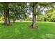 Expansive backyard with a lush lawn, mature trees, and a storage shed, perfect for outdoor activities at 7770 Sherrills Ford Rd, Sherrills Ford, NC 28673