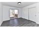 Bright bedroom featuring sliding glass doors to deck and closet with updated gray laminate flooring at 7770 Sherrills Ford Rd, Sherrills Ford, NC 28673