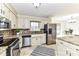 Bright kitchen features stainless steel appliances, granite counters, tile flooring and brick backsplash at 7770 Sherrills Ford Rd, Sherrills Ford, NC 28673