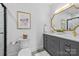 Bathroom featuring dual sinks, a marble countertop, and decorative framed art at 8123 Village Harbor Dr, Cornelius, NC 28031