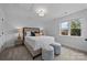 Bright bedroom featuring a large window, neutral color palette, and two stylish ottomans at 8123 Village Harbor Dr, Cornelius, NC 28031