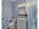Stylish powder room with blue patterned wallpaper and gold accents at 8123 Village Harbor Dr, Cornelius, NC 28031